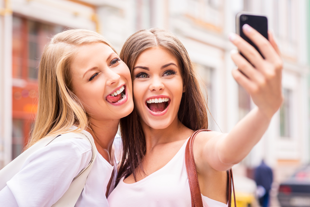 two ladies taking pictures with a good camera phone